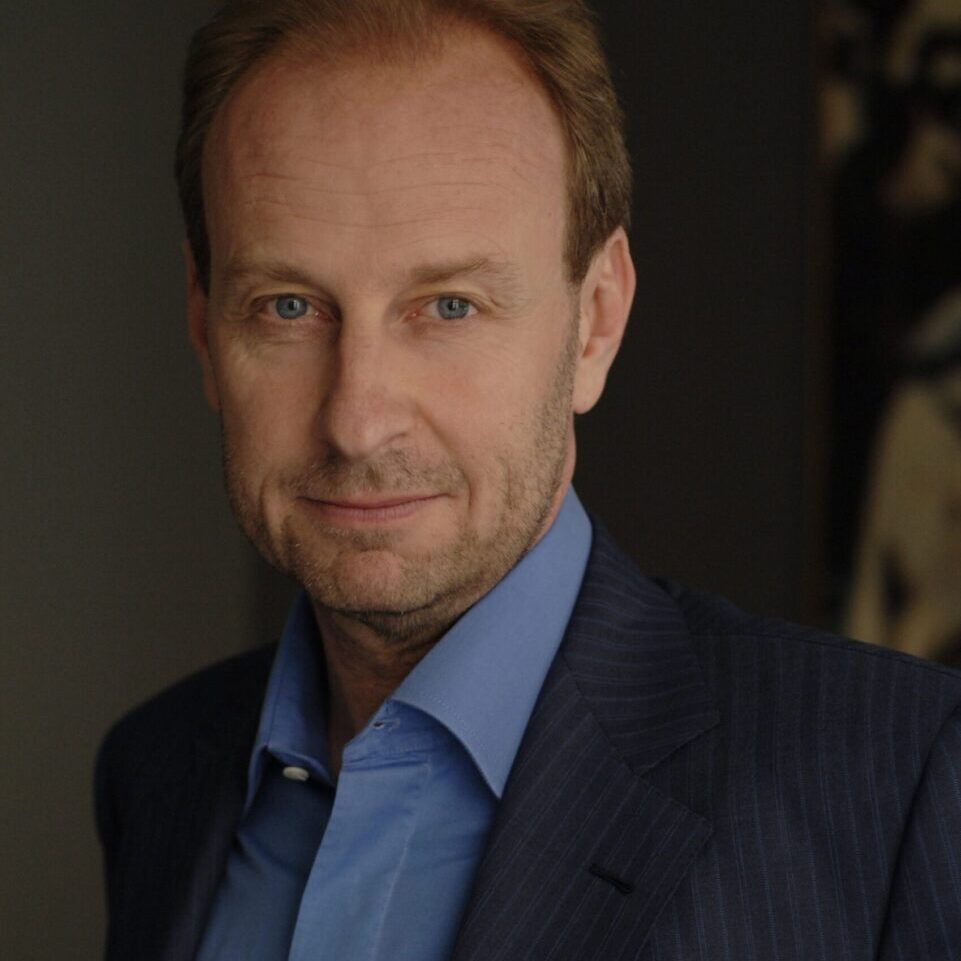 A half-length photograph portrait of a middle-aged Caucasian man in a suit.