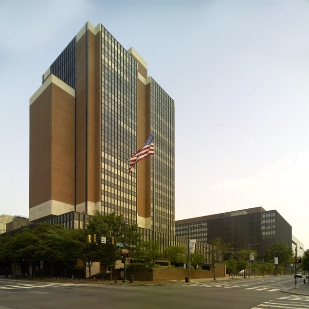 A large brick and glass building with an American flag out front.