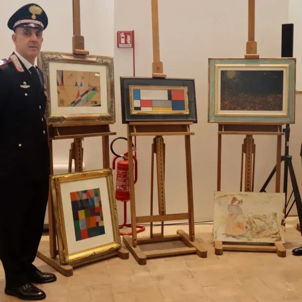 A pair of Italian police officers posing beside easels with forged paintings,