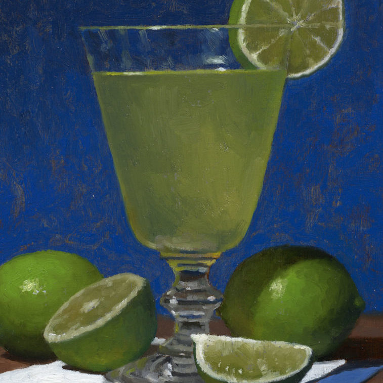 a glass with a cocktail and limes